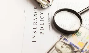 Homeowners insurance policy with a magnifying glass for a roof damage claim